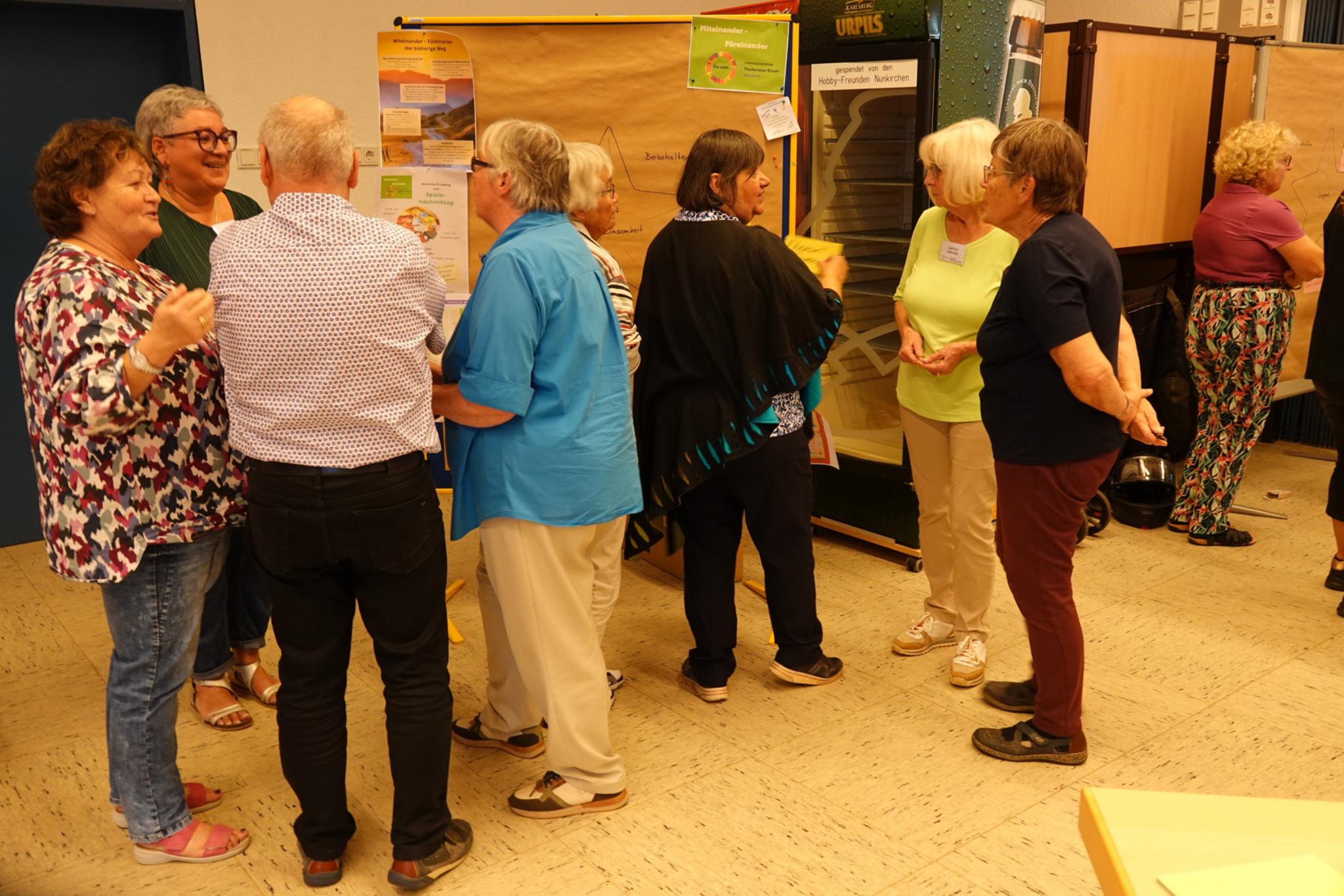 Menschen stehen vor Pinnwänden und reden miteinander_ Eindrücke aus der zweiten Synodalversammlung des Pastoralen Raumes Wadern