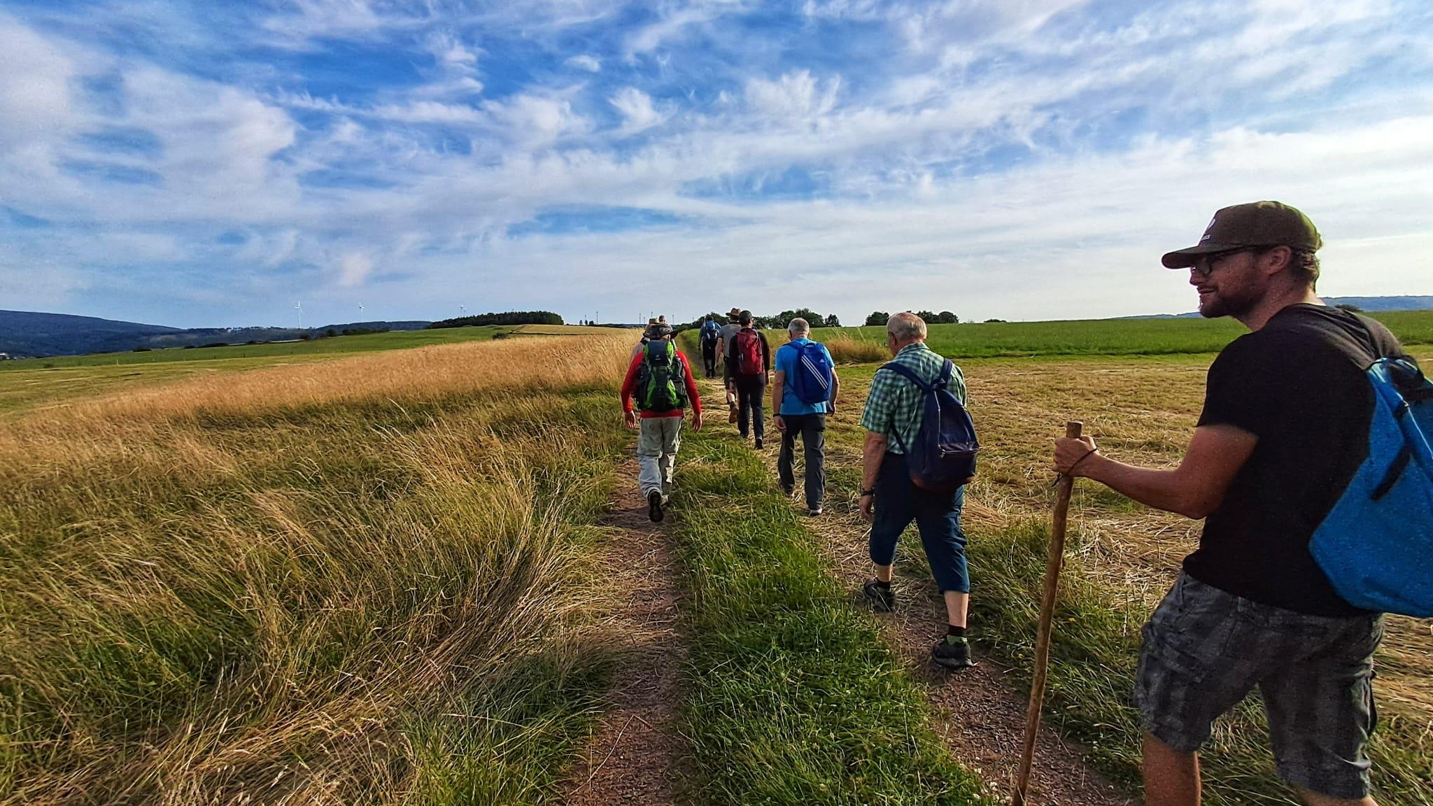 Männer wandern über eine grüne Wiese
