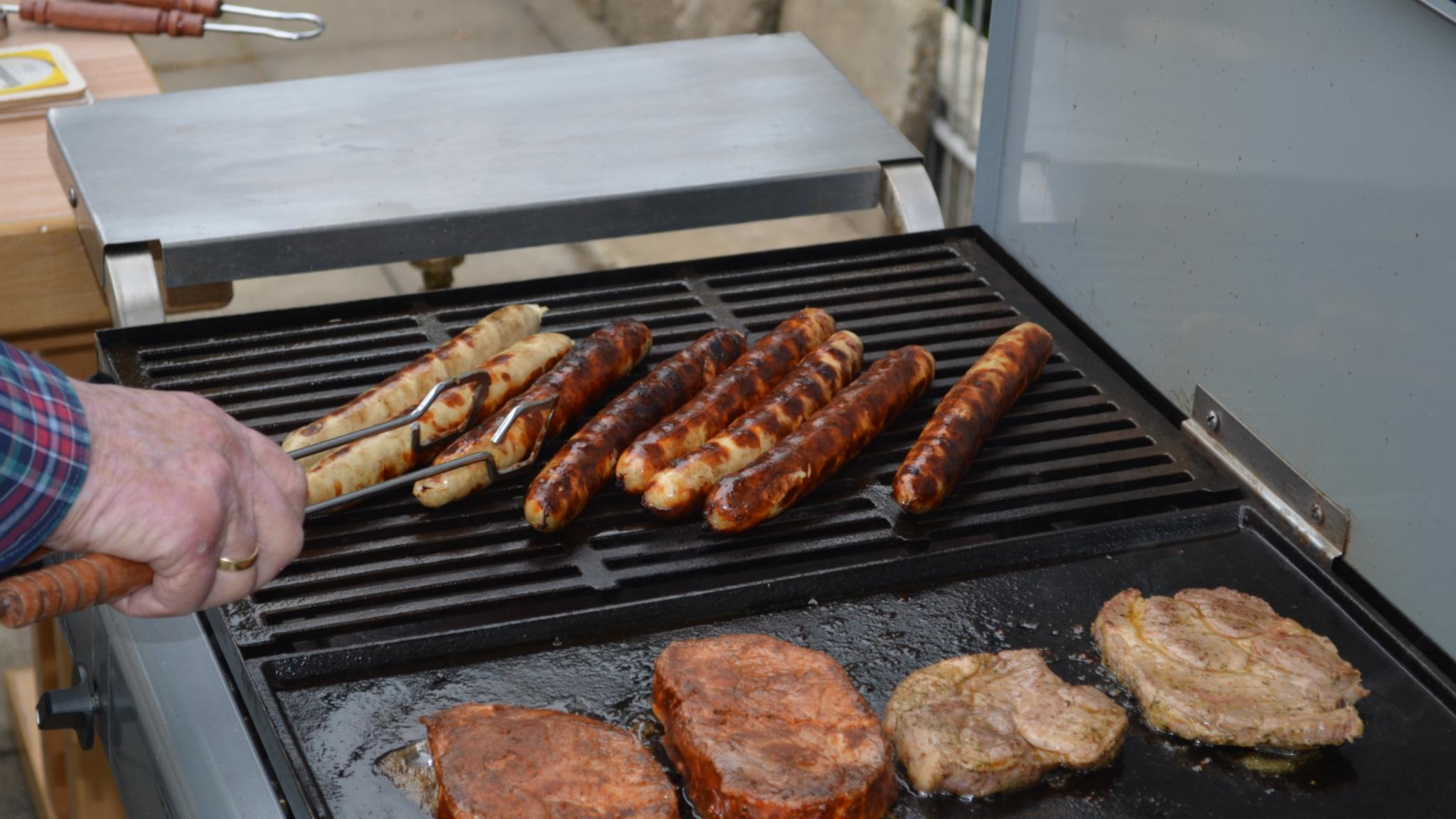 Auf dem Grill finden sich Würste und Schwenker